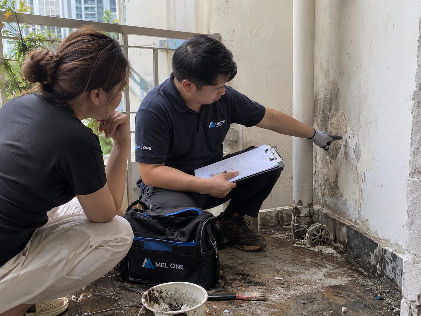 MEL ONE discussing a deteriorated exterior wall area and recording visible conditions